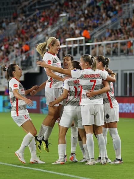 Women's team celebrating a goal together