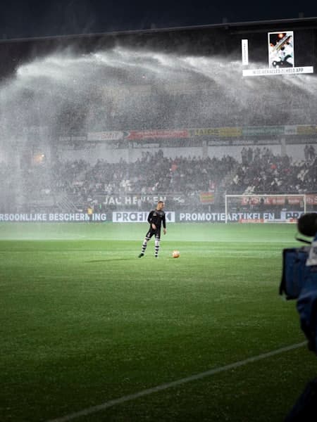 Lone player warming up while the sprinklers run