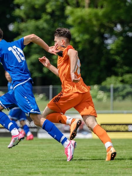 Two players from opposing teams racing for the ball