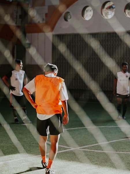 Player in a training bib crossing an indoor pitch